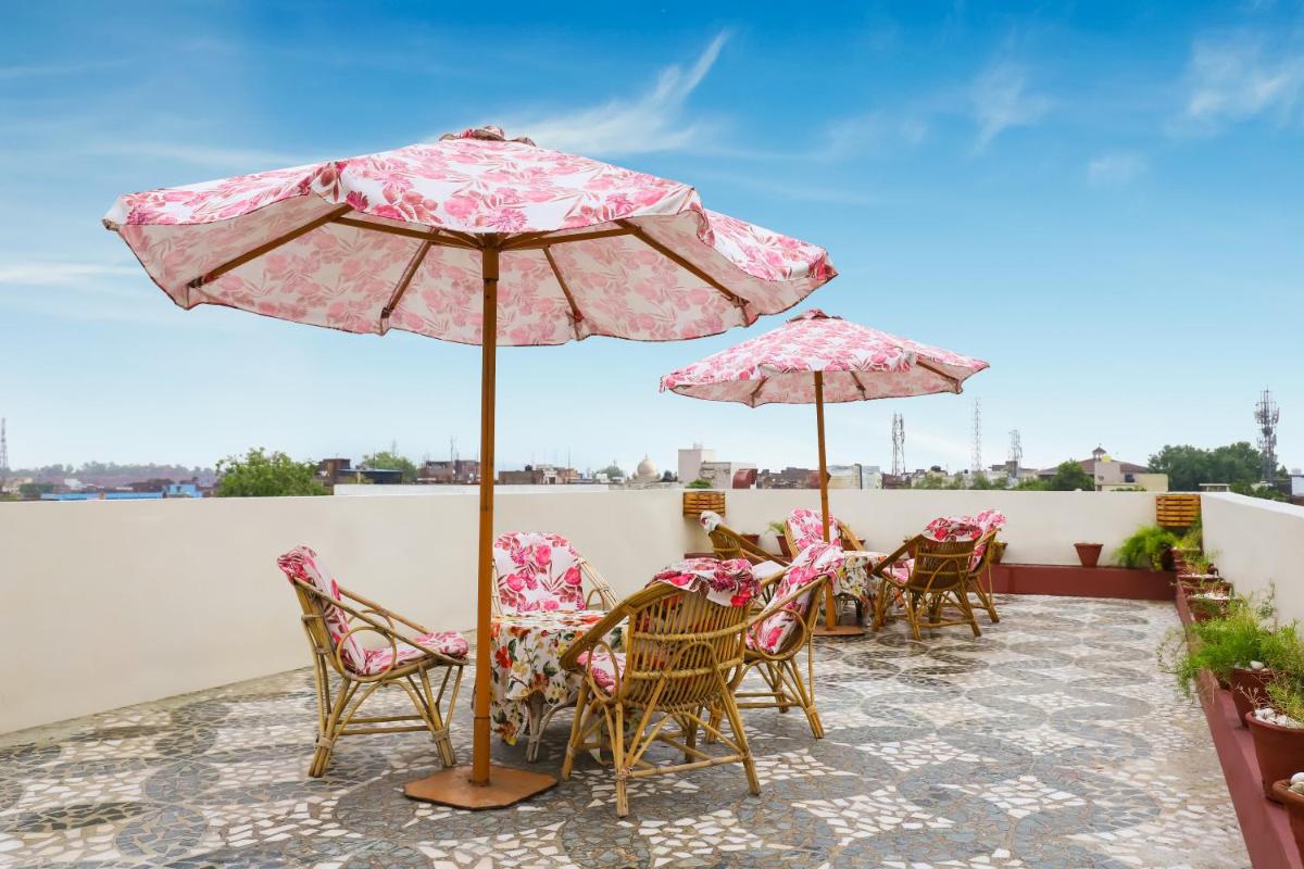 a patio with chairs and tables with umbrellas at The Grand Imperial - Heritage Hotel in Agra