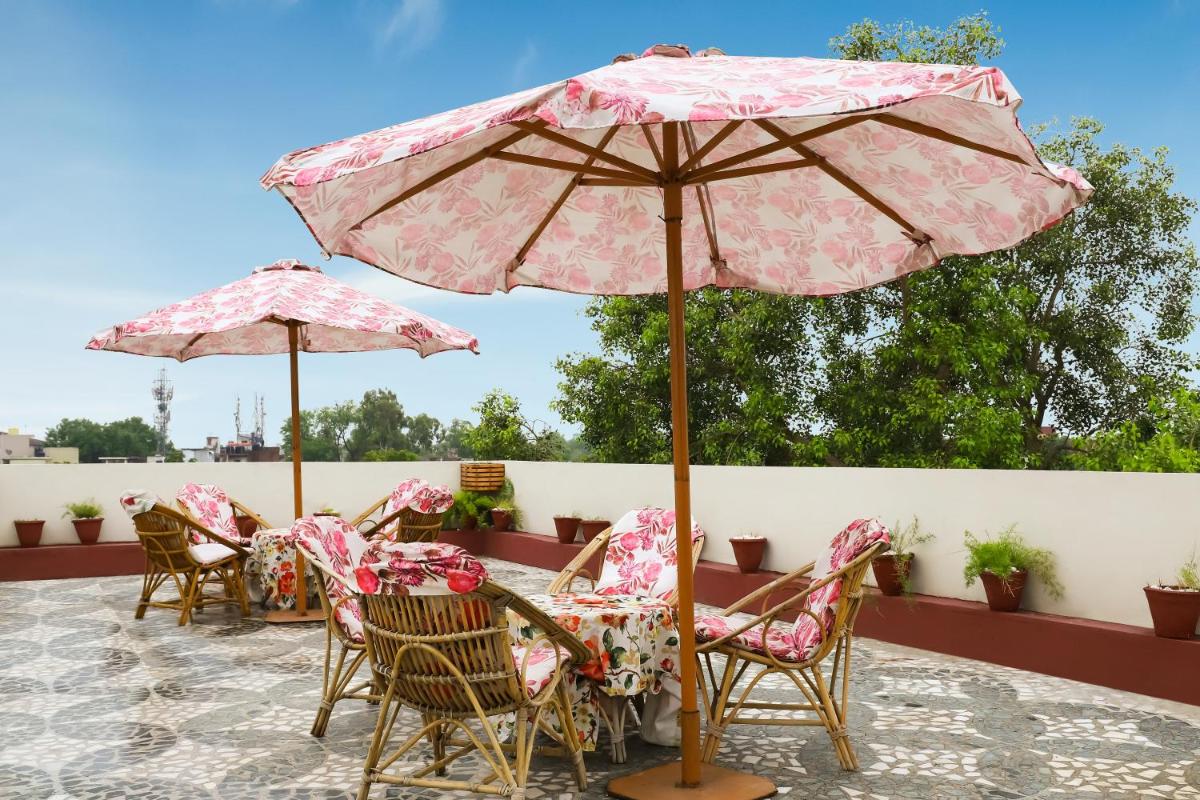 a patio with tables and chairs under an umbrella at The Grand Imperial - Heritage Hotel in Agra
