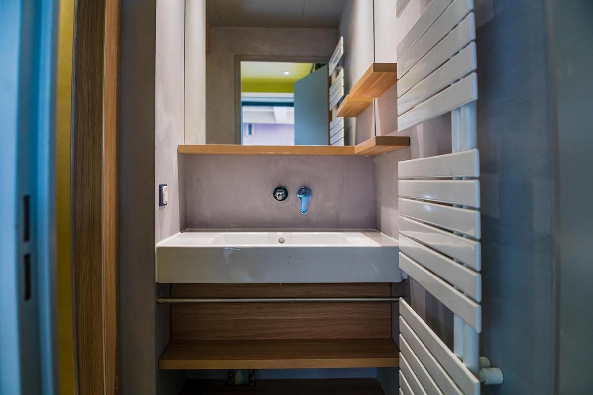 une salle de bain avec un lavabo blanc et un miroir dans l'établissement YOOMA Urban Lodge Tour Eiffel, à Paris
