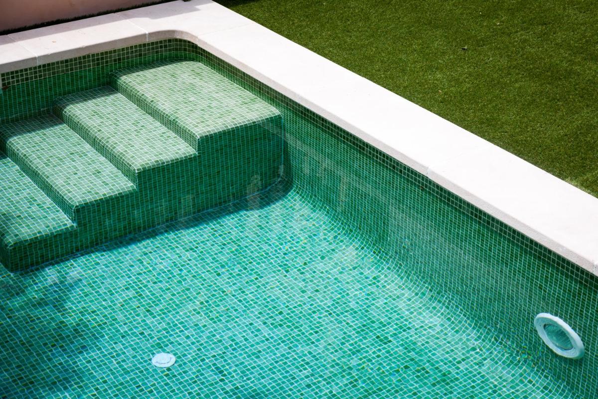 una vista aérea de una piscina con azulejos verdes en Hotel El Guía, en Sóller