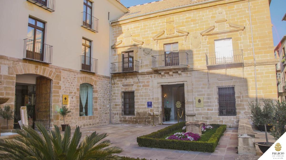 Un gran edificio de ladrillo con un patio delante. en Hotel Palacio De Úbeda 5 G.L, en Úbeda