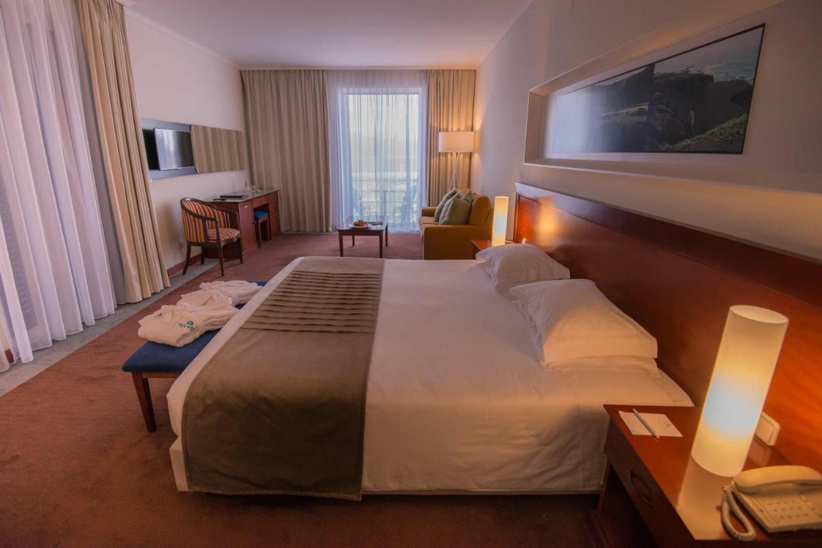 um quarto de hotel com uma cama grande num quarto em Azoris Faial Garden – Resort Hotel em Horta