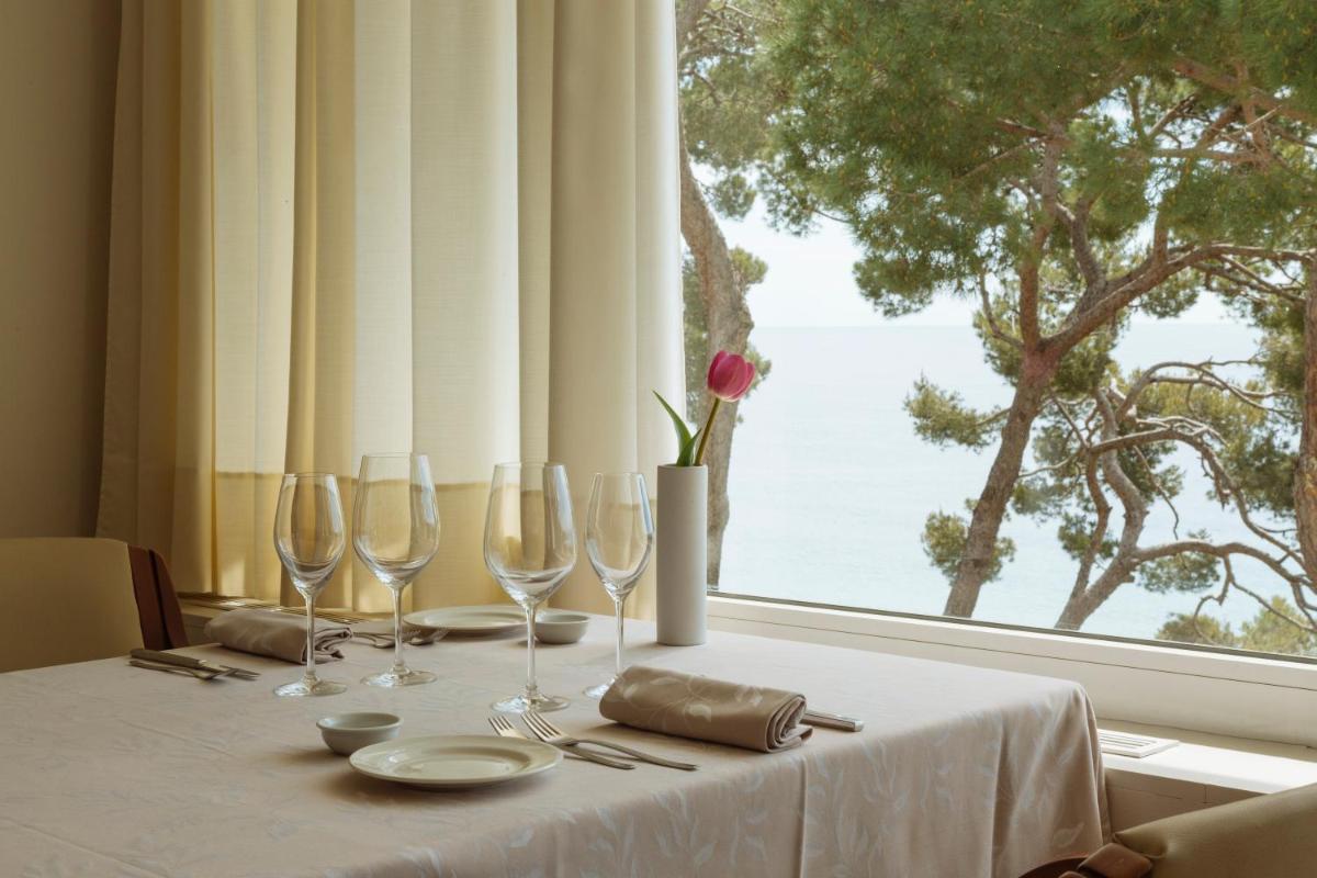 una mesa con copas de vino y una gran ventana en Hotel Santa Marta, en Lloret de Mar