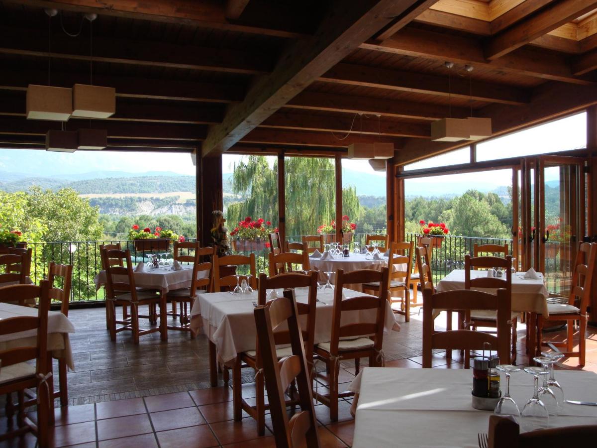 Un restaurante con mesas y sillas con vistas. en Hotel & SPA Peña Montañesa, en Aínsa