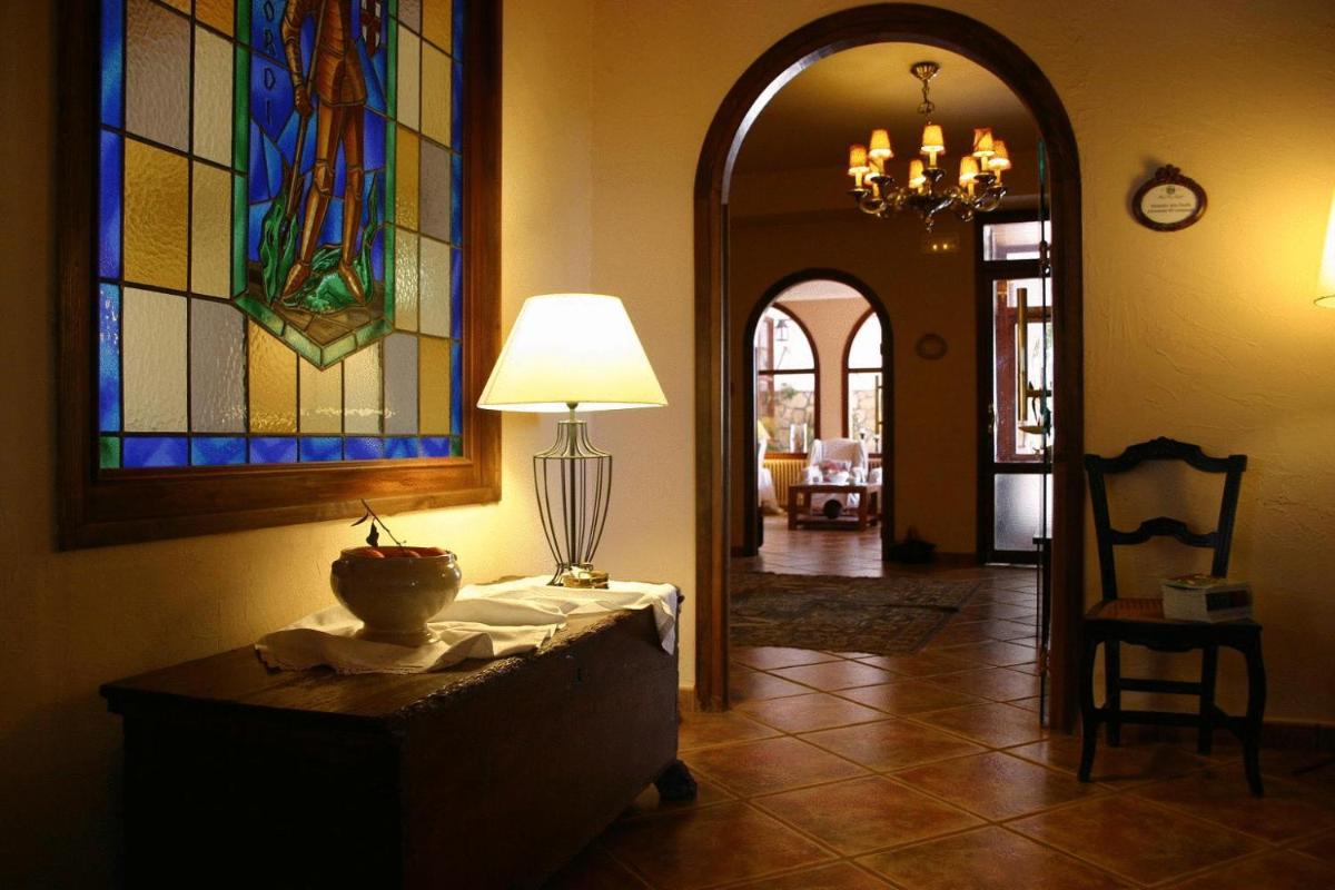 pasillo con mesa con lámpara y vidrieras en Hotel Golf Can Rafel, en Corbera de Llobregat