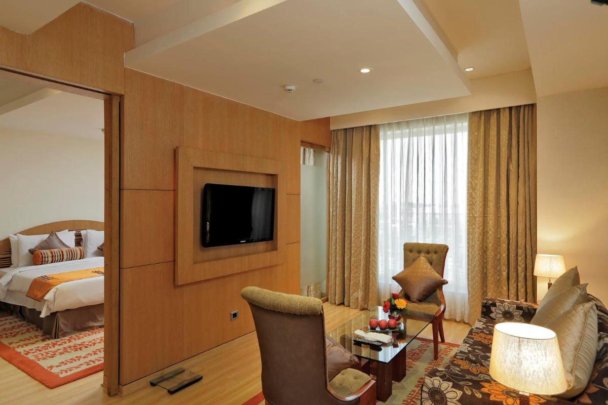 a hotel room with a bed and a television at Yashail Hotel Haridwar in Haridwār