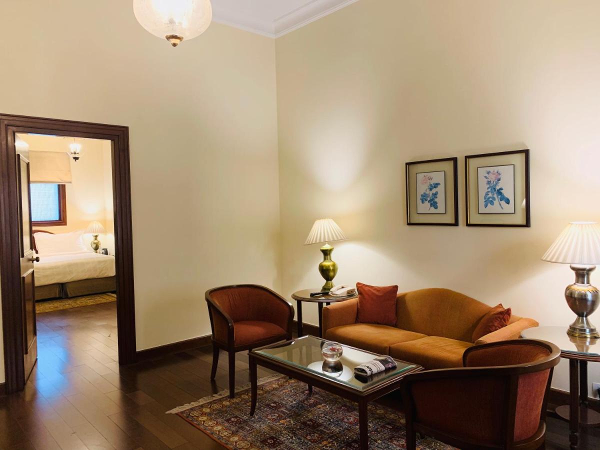 a living room with a couch and a table at Maidens Hotel New Delhi in New Delhi