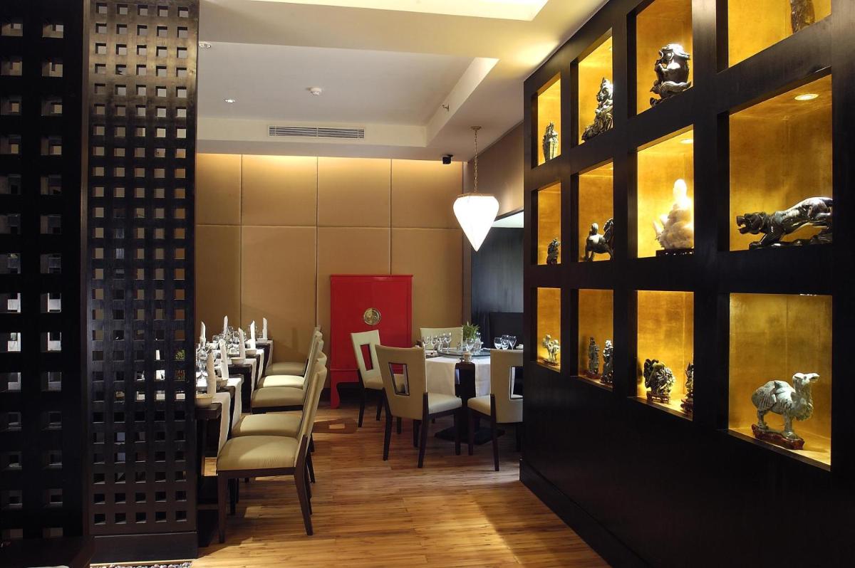 a restaurant with tables and chairs in a room at The Claridges New Delhi in New Delhi a restaurant with tables and chairs in a room at The Claridges New Delhi in New Delhi