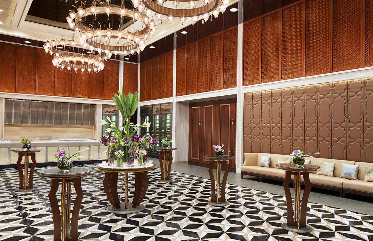 a lobby with couches and flowers on tables and chandeliers at Four Seasons Hotel Mumbai in Mumbai