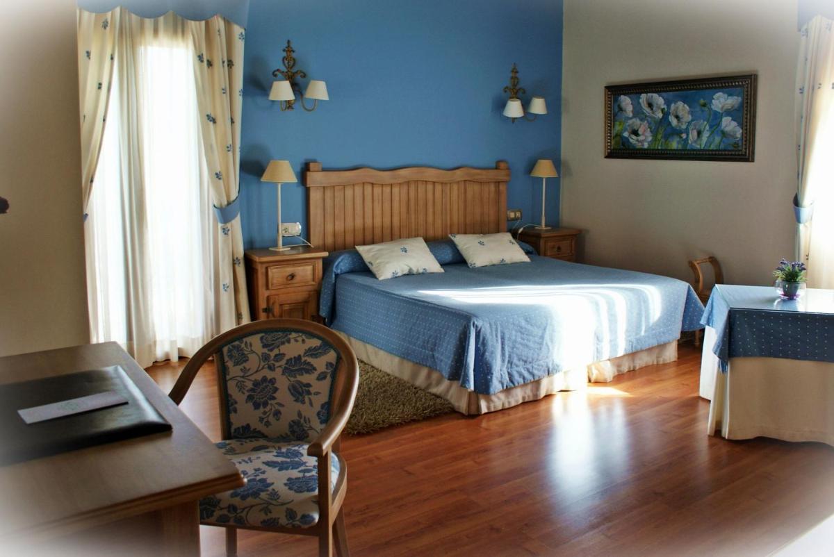 Un dormitorio con una cama con paredes azules y una mesa. en Cortijo Salinas, en Montecorto