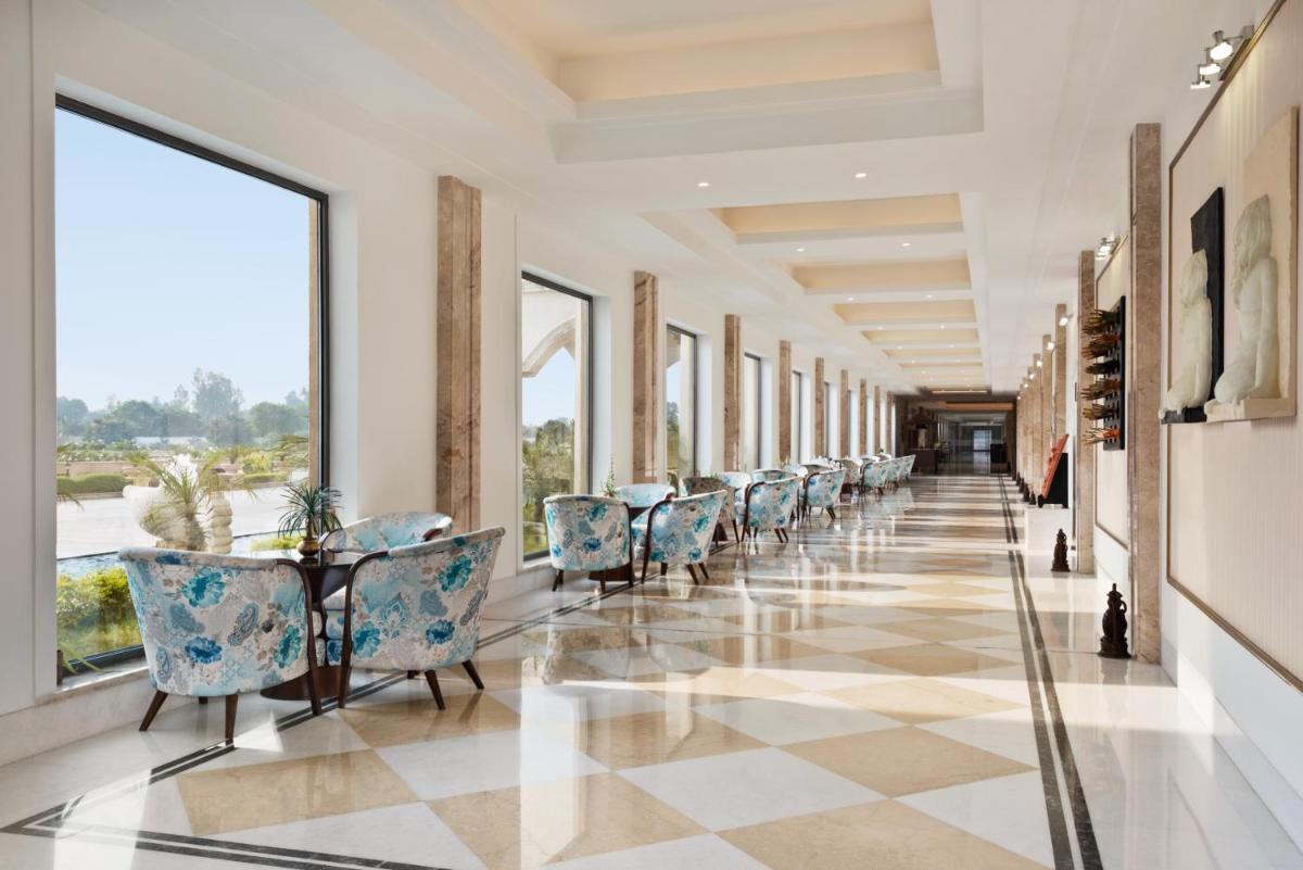 a hallway with chairs and tables and windows at Ramada Plaza by Wyndham Lucknow in Lucknow