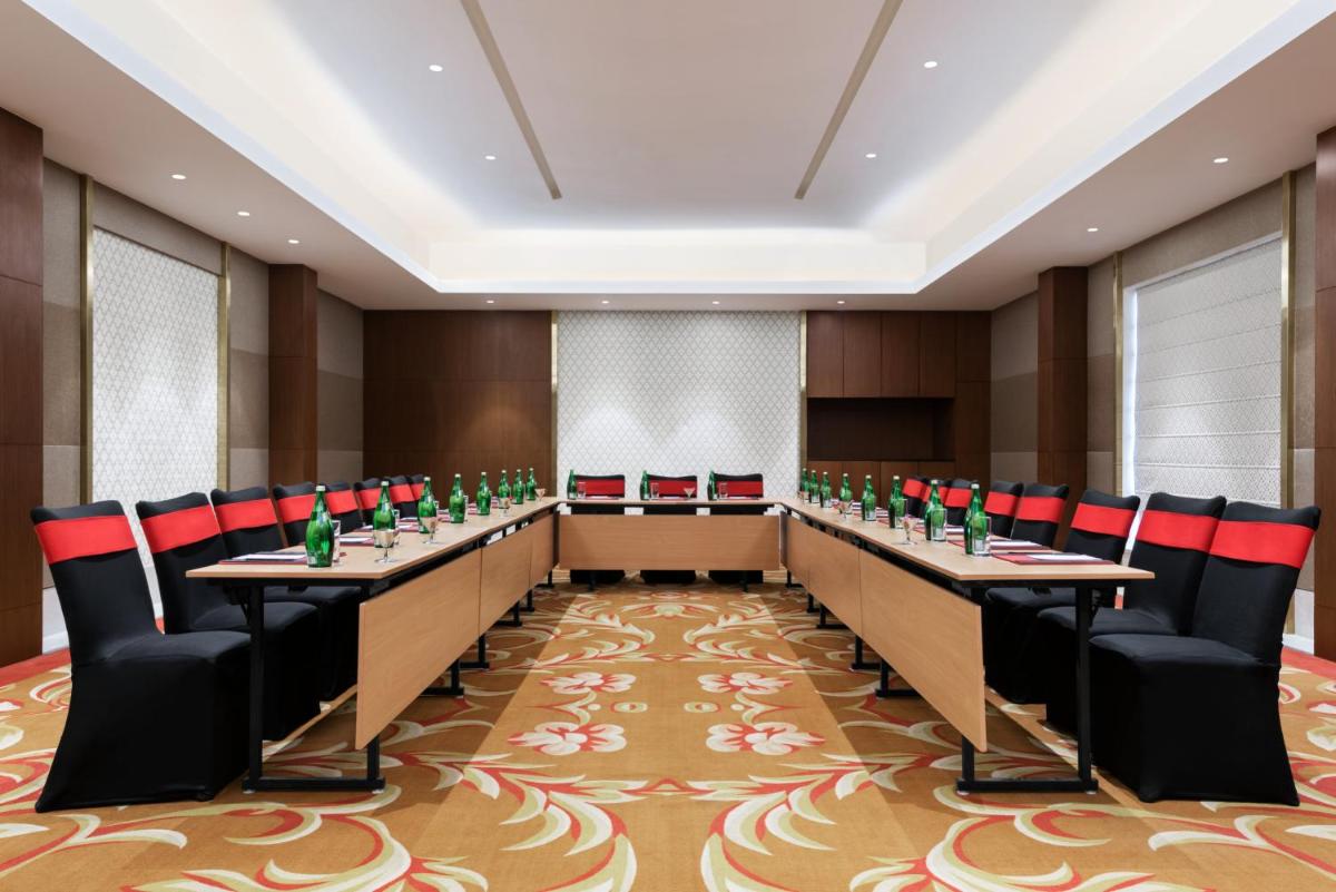 a conference room with long tables and chairs at Ramada Plaza by Wyndham Lucknow in Lucknow