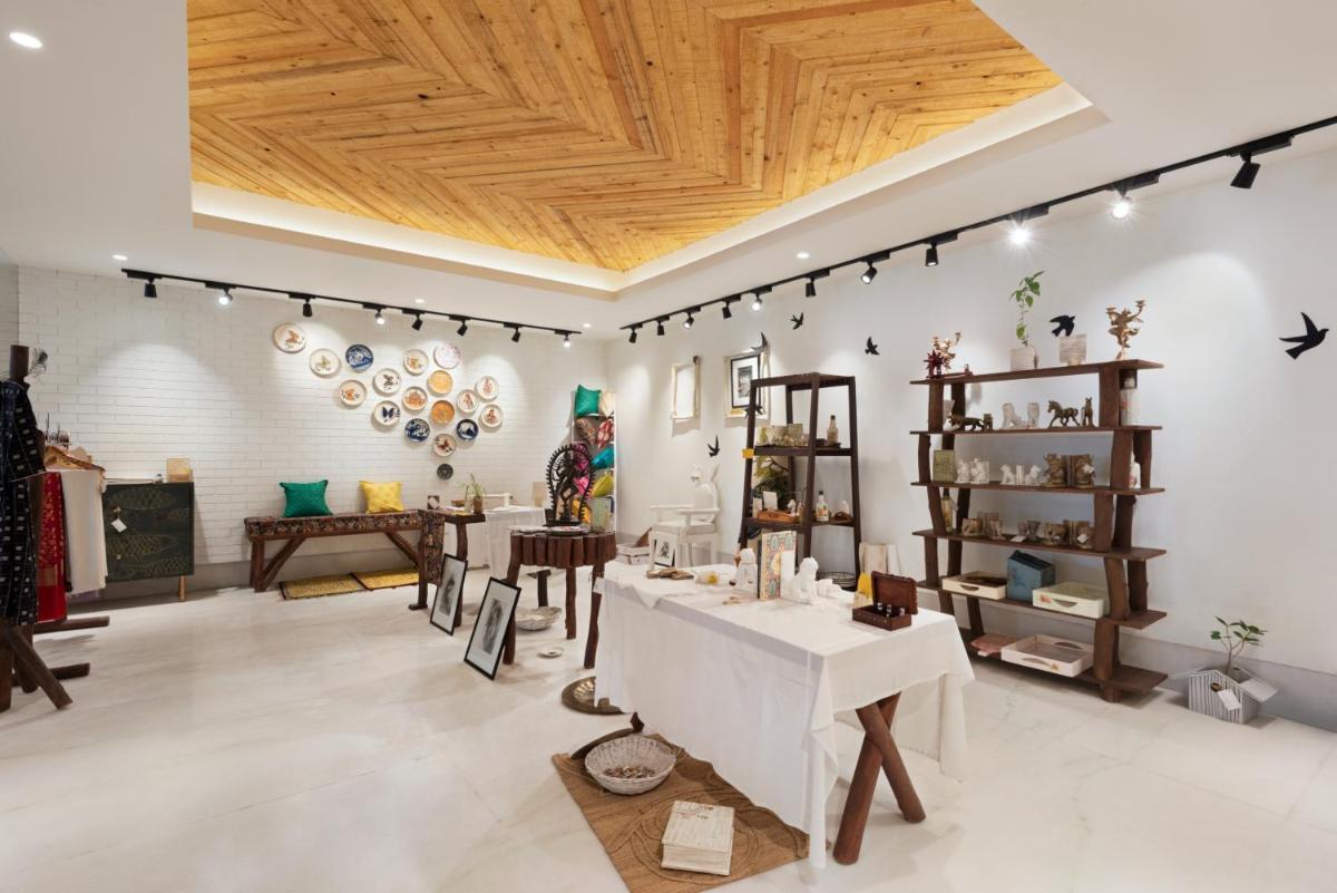a store with wooden ceilings and tables and chairs at Ramada Plaza by Wyndham Lucknow in Lucknow