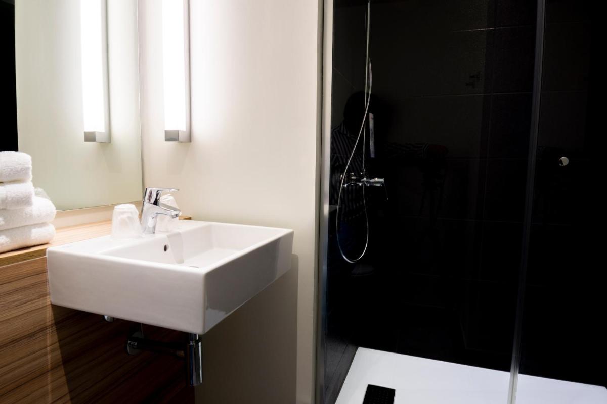 une salle de bain avec un lavabo blanc et une douche dans l'établissement Hotel Campanile Montpellier Centre St Roch, à Montpellier 34 autres photos
