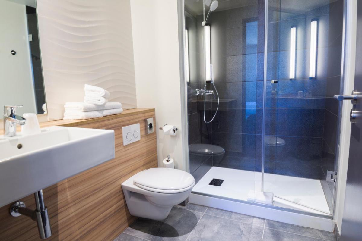 une salle de bain avec une douche, des toilettes et un lavabo dans l'établissement Hotel Campanile Montpellier Centre St Roch, à Montpellier
