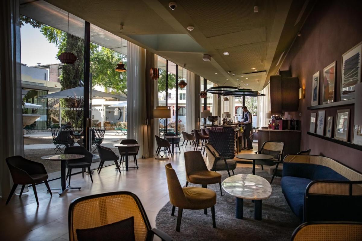 un restaurant avec des tables, des chaises et des fenêtres dans l'établissement Maison Albar Hotels L’Imperator, à Nîmes