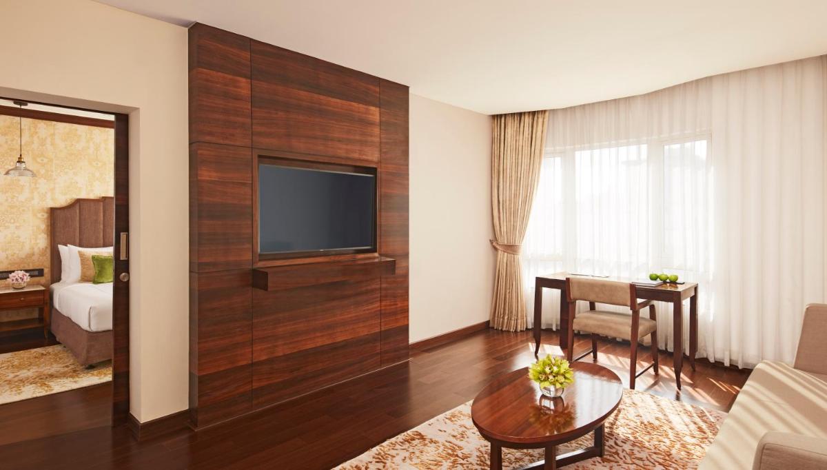 a living room with a television on a wall at President - IHCL SeleQtions in Mumbai