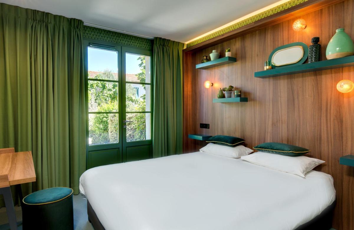 une chambre avec un lit blanc et une fenêtre dans l'établissement Hôtel Montmorency & Spa, à Carcassonne