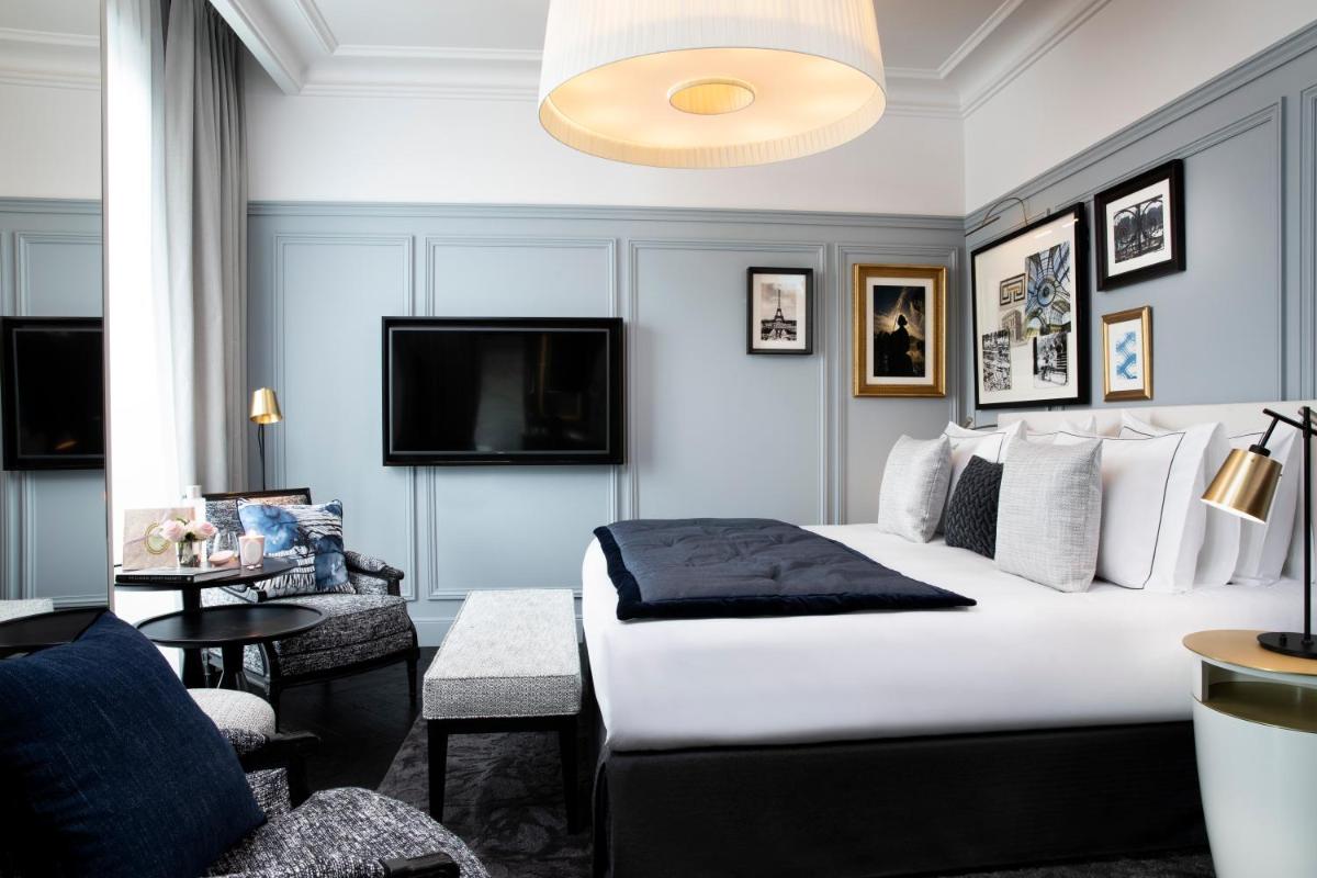 une chambre d'hôtel avec un lit et une télévision dans l'établissement Le Damantin Hôtel & Spa, à Paris