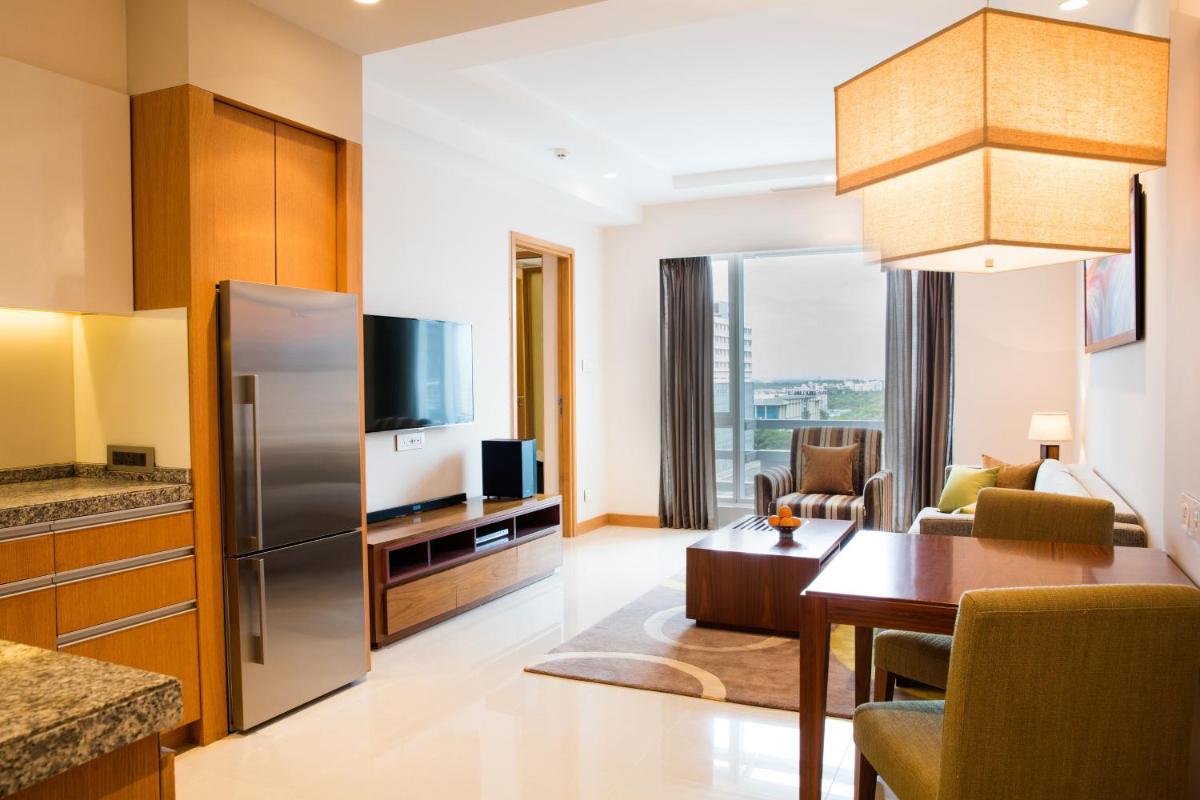 a kitchen and living room with a stainless steel refrigerator at Oakwood Residence Kapil Hyderabad in Hyderabad
