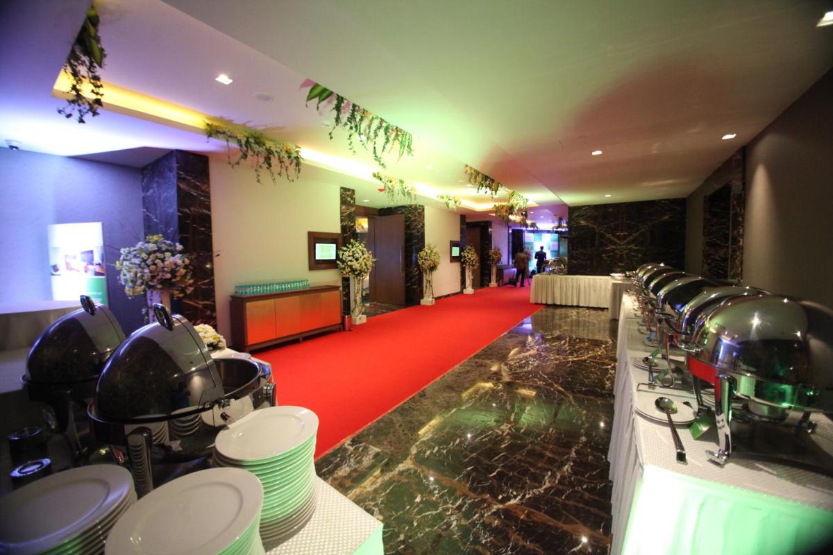 a large room with a red carpet and a long line of dishes at Oakwood Residence Kapil Hyderabad in Hyderabad