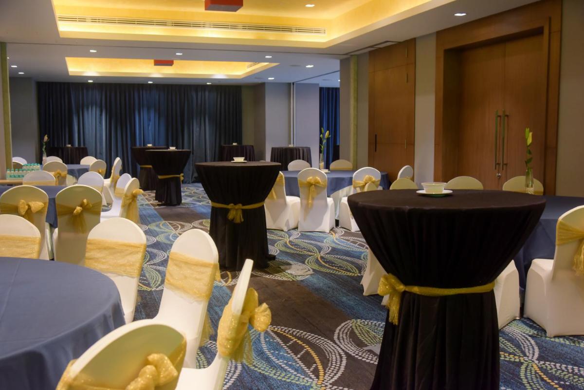 a banquet hall with tables and chairs in a room at Oakwood Residence Kapil Hyderabad in Hyderabad