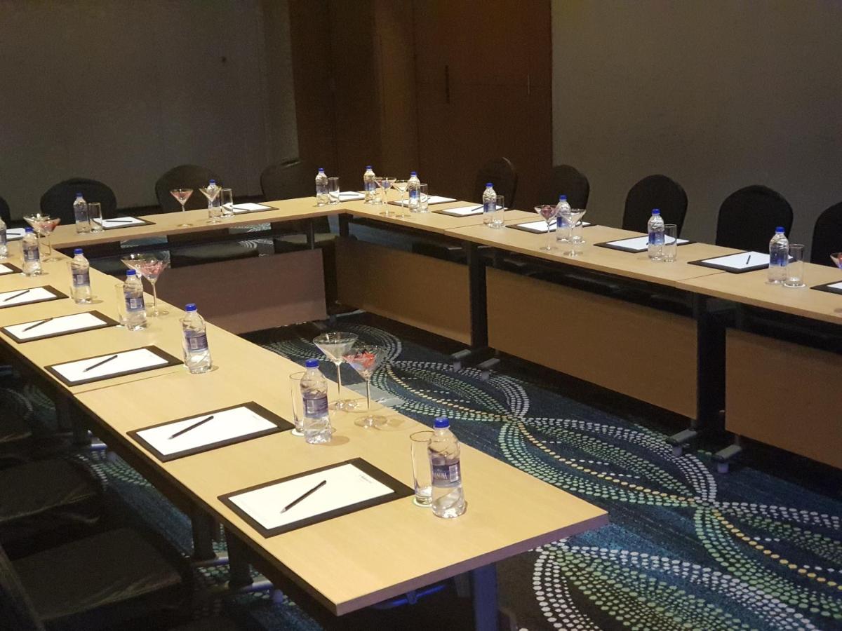 a group of tables in a large room with chairs at Oakwood Residence Kapil Hyderabad in Hyderabad