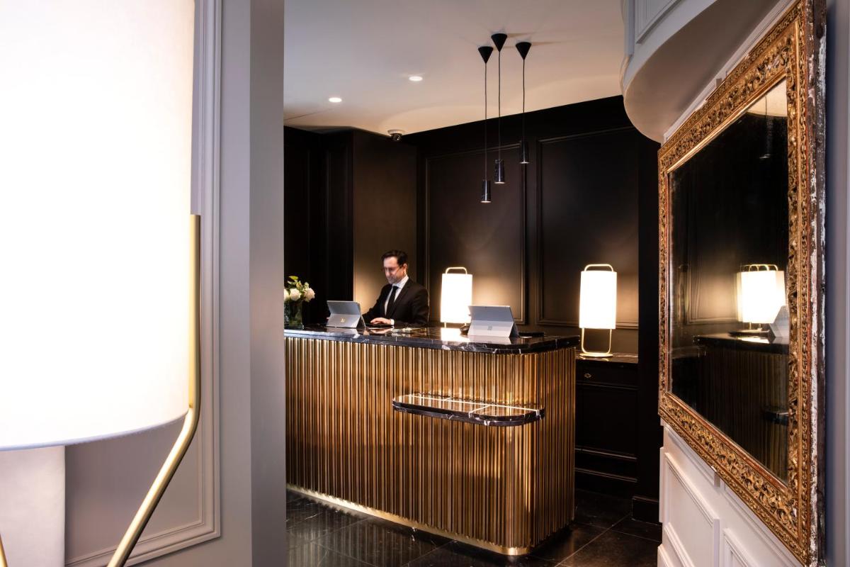 un homme assis au bar dans une pièce avec miroir dans l'établissement Le Damantin Hôtel & Spa, à Paris 37 autres photos