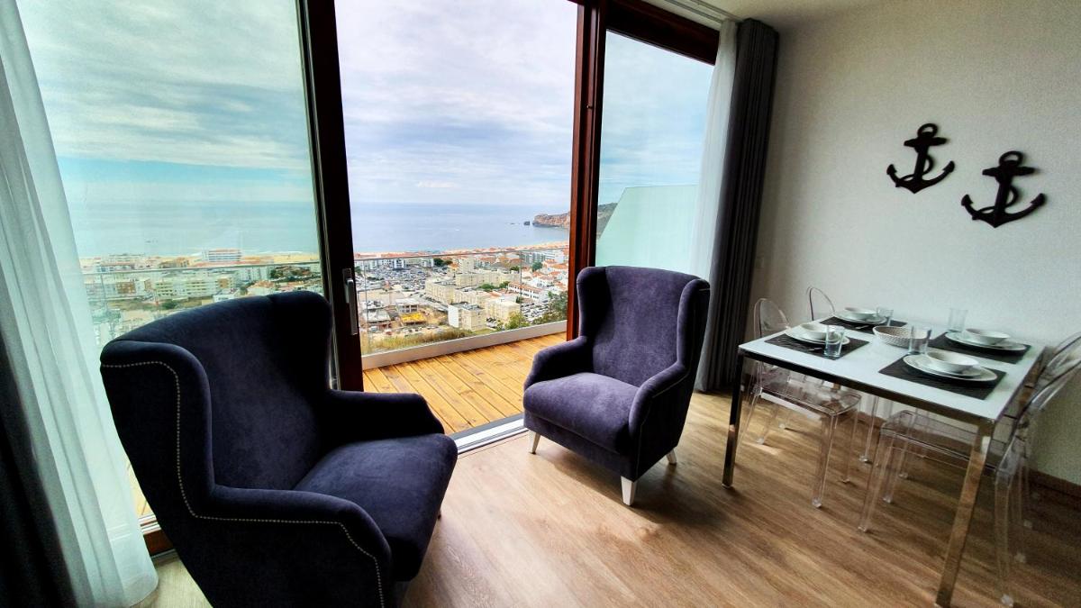 um quarto com duas cadeiras e uma mesa e uma grande janela em Miramar Hotel Spa & Apartments na Nazaré mais 42 fotografias