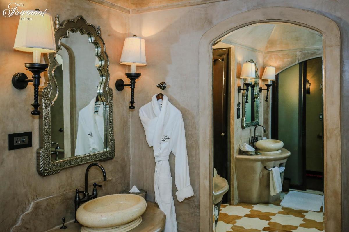 a bathroom with a white robe hanging on a wall at Fairmont Jaipur in Jaipur