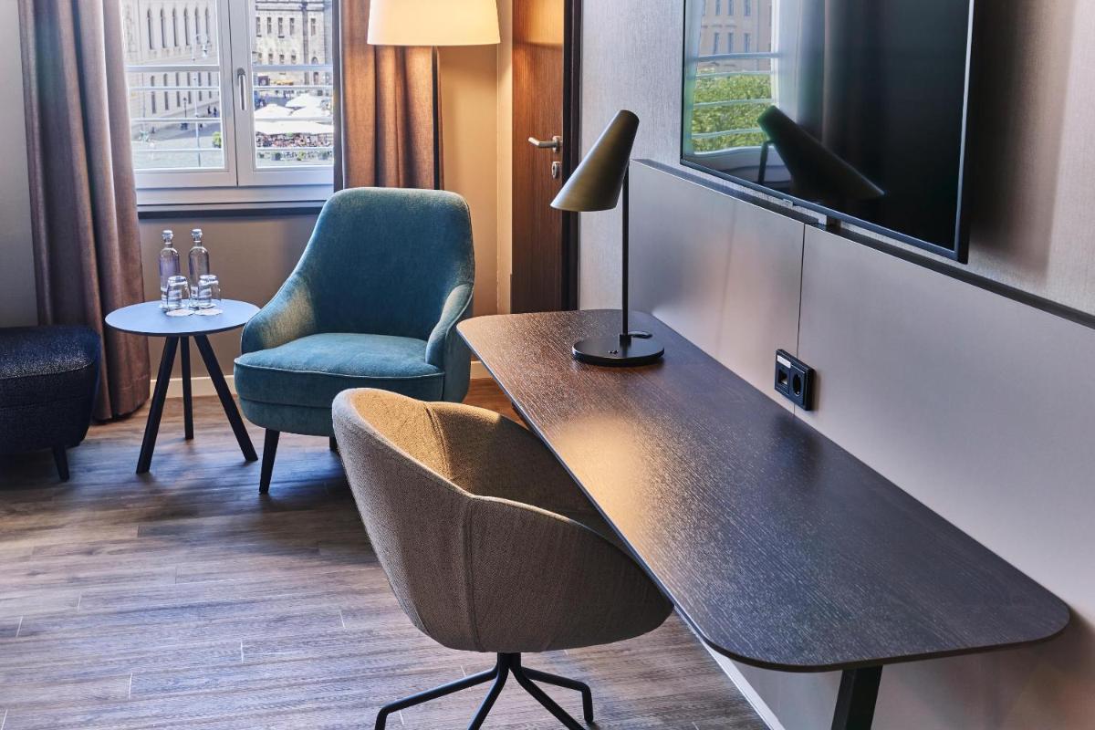 Zimmer mit einem Tisch, einem Stuhl und einer Lampe in der Unterkunft Steigenberger Hotel de Saxe in Dresden Zimmer mit einem Tisch, einem Stuhl und einer Lampe in der Unterkunft Steigenberger Hotel de Saxe in Dresden