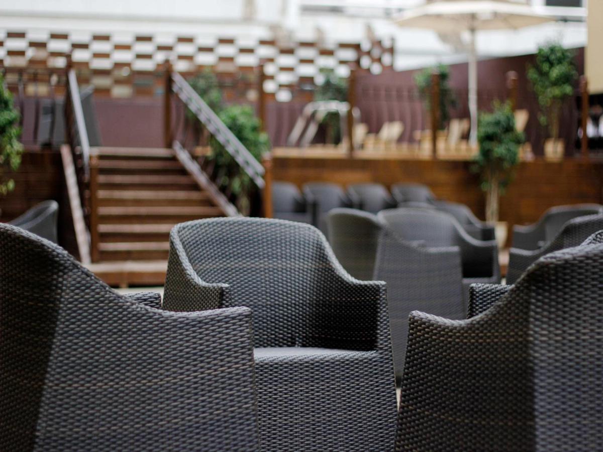 a row of chairs in a restaurant with stairs at Sterlings Mac Hotel in Bengaluru