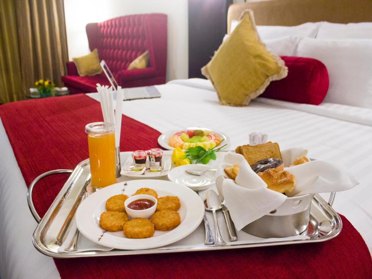 a tray of food on a bed in a hotel room at Sterlings Mac Hotel in Bengaluru