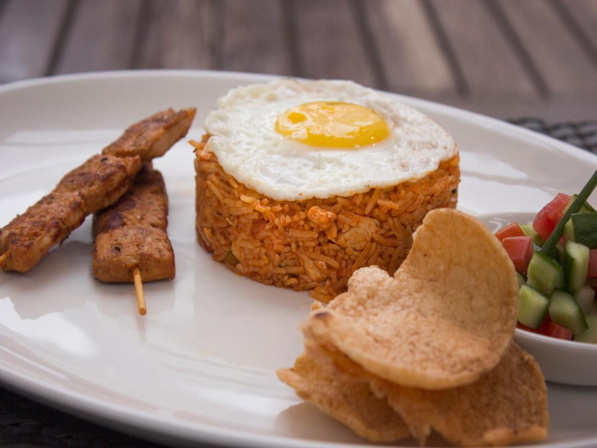 a plate of food with an egg and sausage and vegetables at Sterlings Mac Hotel in Bengaluru