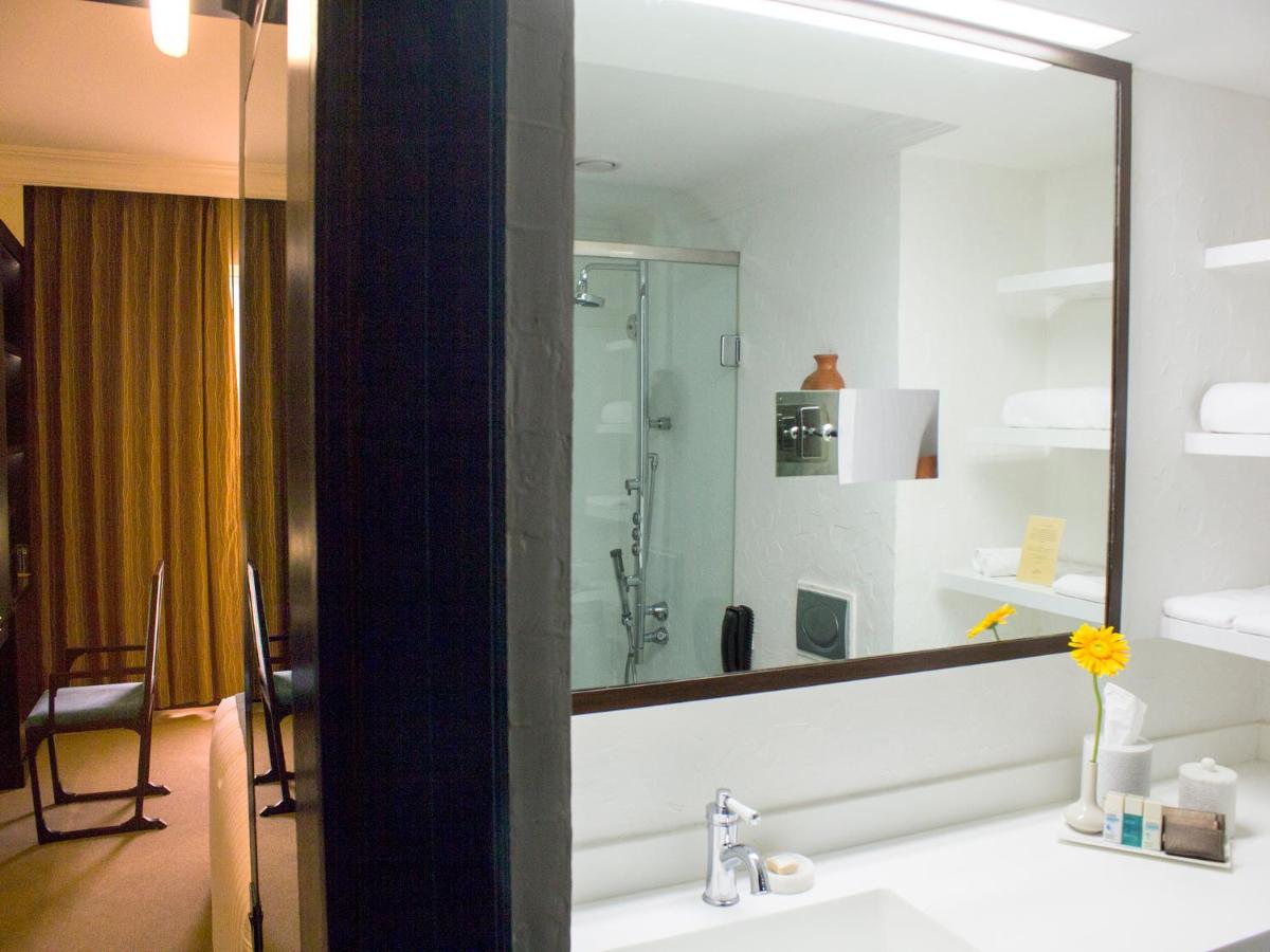 a bathroom with a sink and a large mirror at Sterlings Mac Hotel in Bengaluru a bathroom with a sink and a large mirror at Sterlings Mac Hotel in Bengaluru
