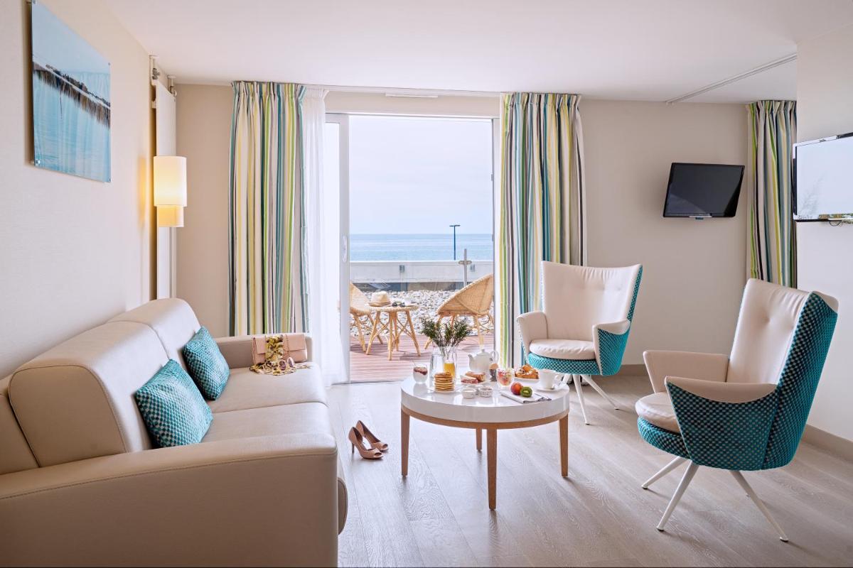 un salon avec un canapé, des fauteuils et une table dans l'établissement Hôtel de la Baie - Thalassothérapie PREVITHAL, à Donville-les-Bains