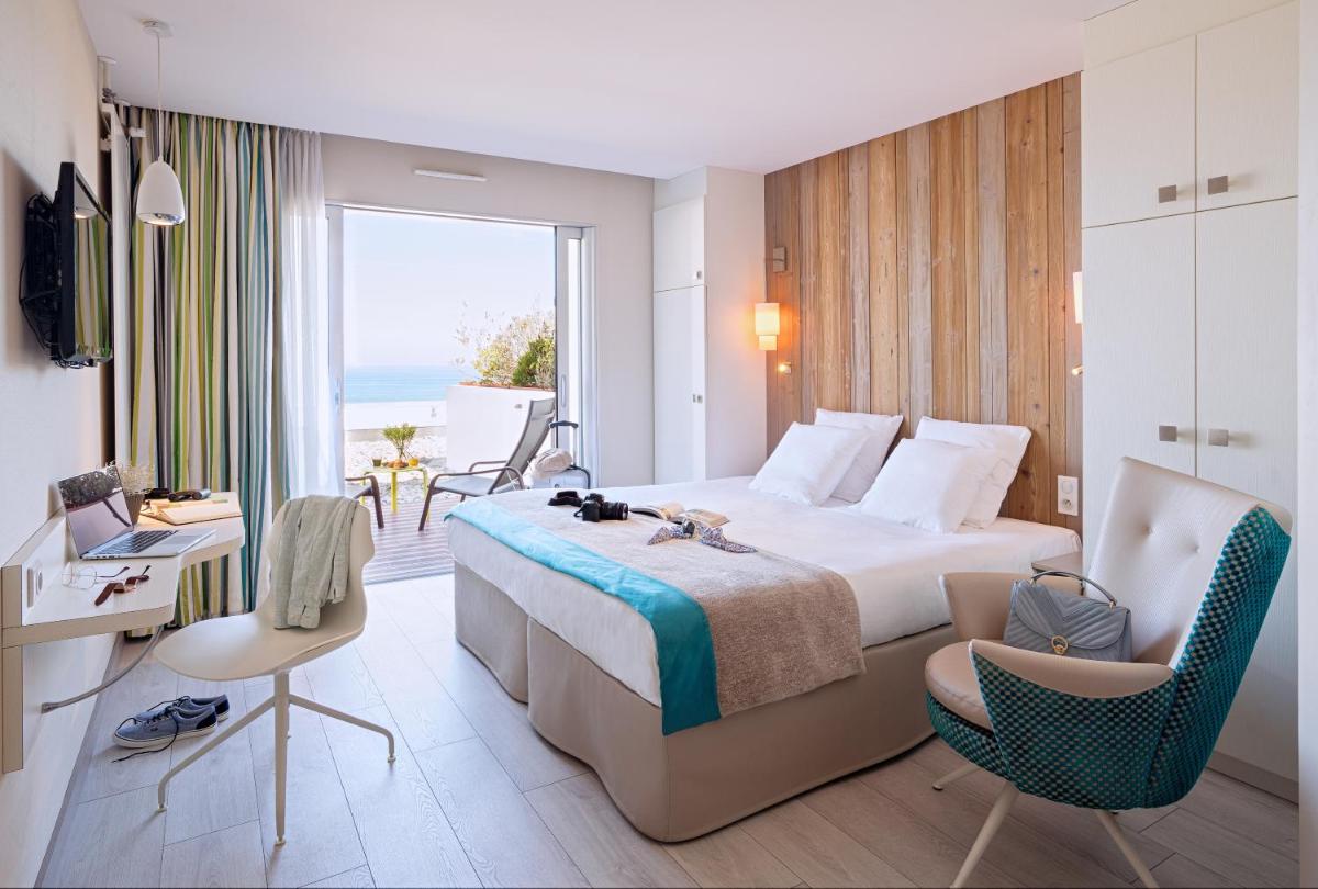 une chambre d'hôtel avec un lit et une vue sur l'océan dans l'établissement Hôtel de la Baie - Thalassothérapie PREVITHAL, à Donville-les-Bains