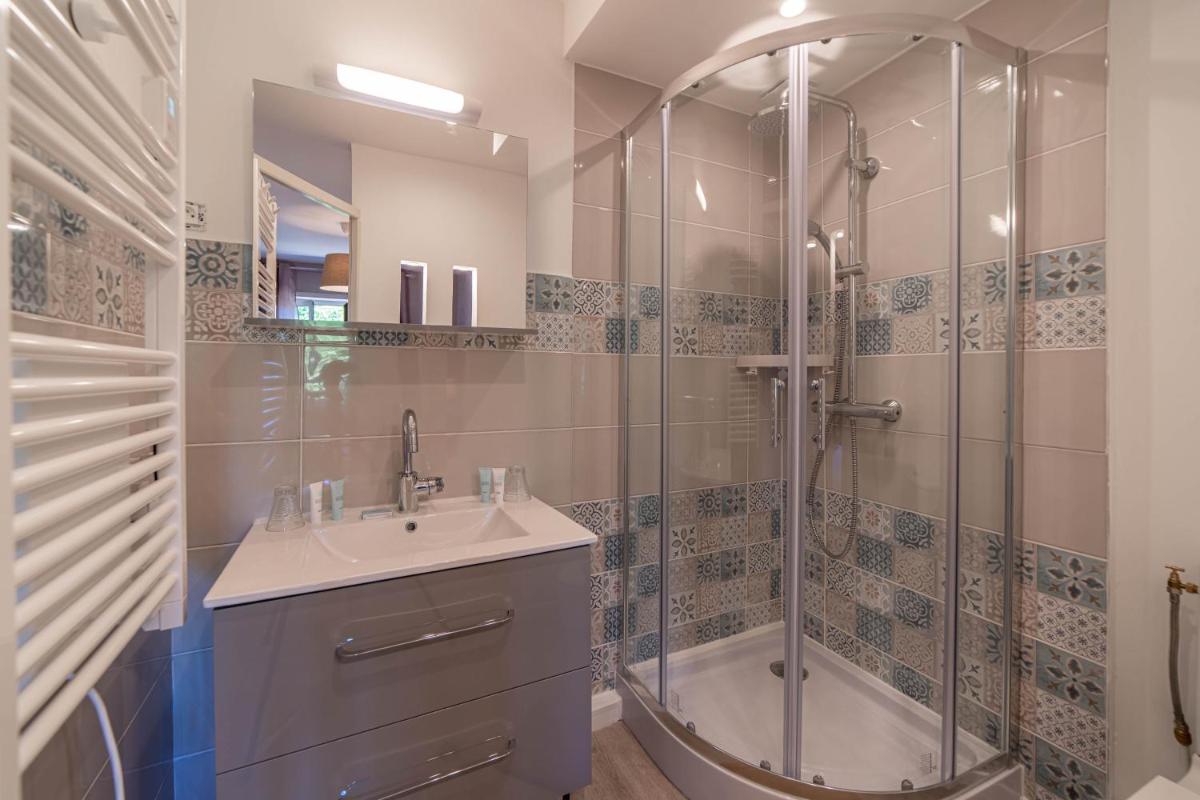 une salle de bain avec une douche, un lavabo et une baignoire dans l'établissement Hôtel Au Coq Dort Spa, à Châtillon-sur-Chalaronne
