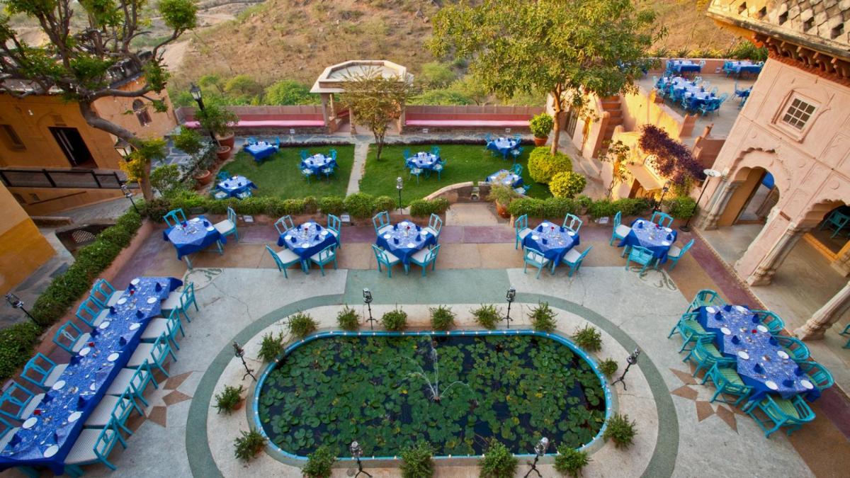 an overhead view of a restaurant with blue tables and chairs at Neemrana Fort-Palace in Neemrana