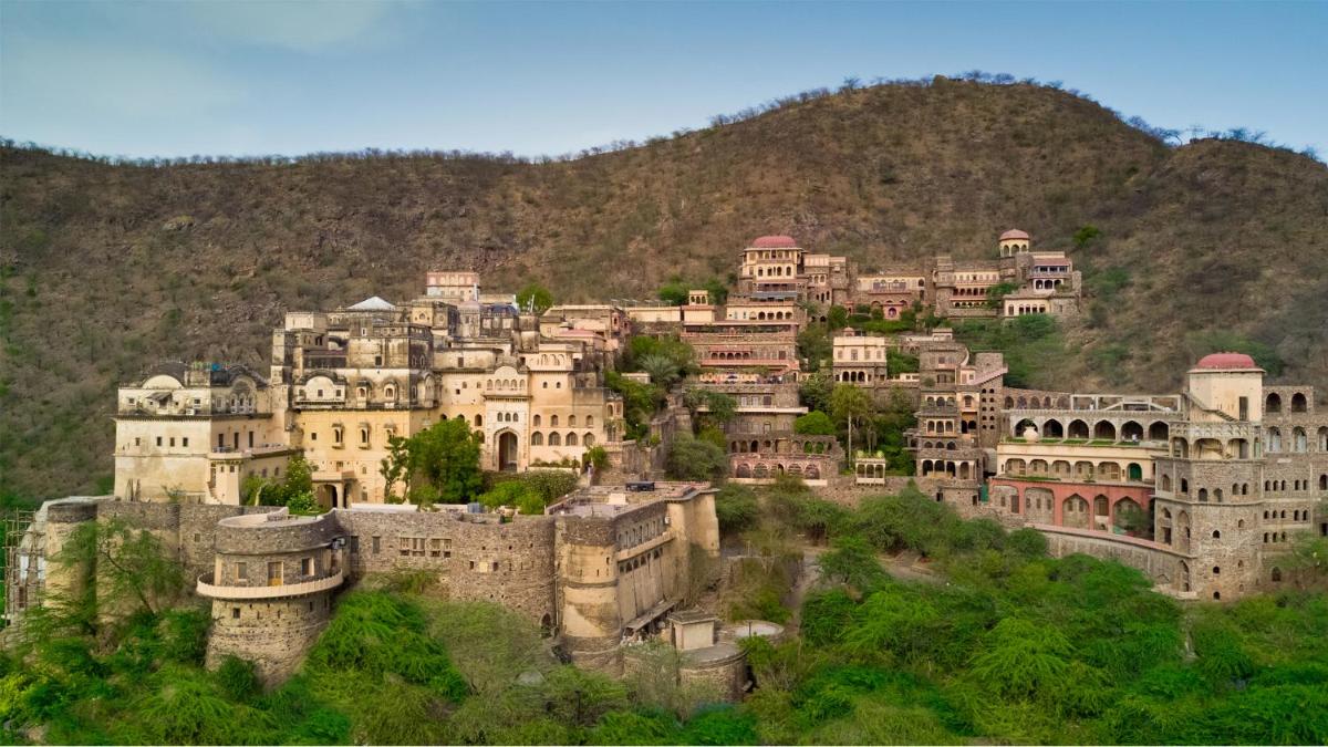 a large group of buildings on a mountain at Neemrana Fort-Palace in Neemrana