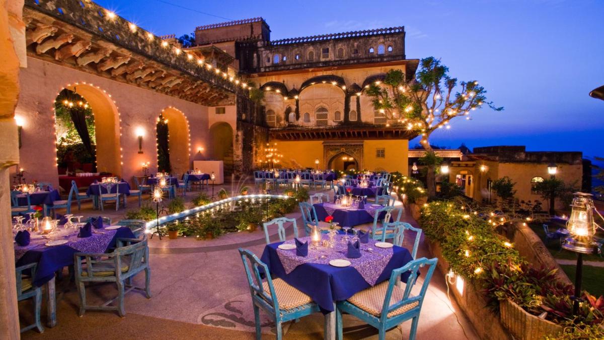 a venue with tables and chairs in front of a building at Neemrana Fort-Palace in Neemrana