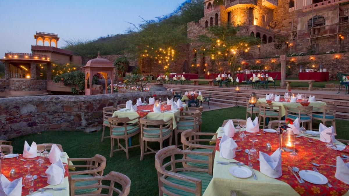 a restaurant with tables and chairs and a building at Neemrana Fort-Palace in Neemrana