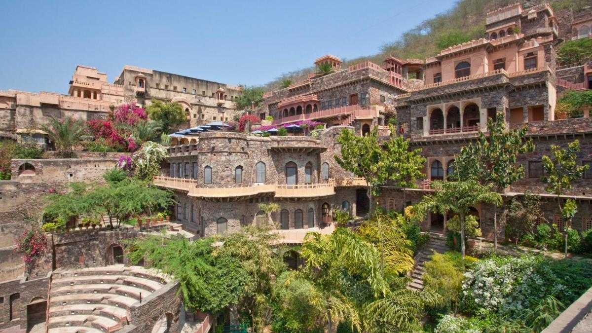 a large building on the side of a mountain at Neemrana Fort-Palace in Neemrana