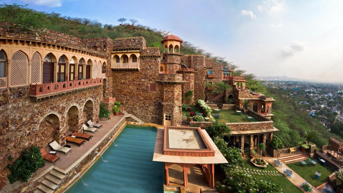 a castle with a pool in front of a building at Neemrana Fort-Palace in Neemrana