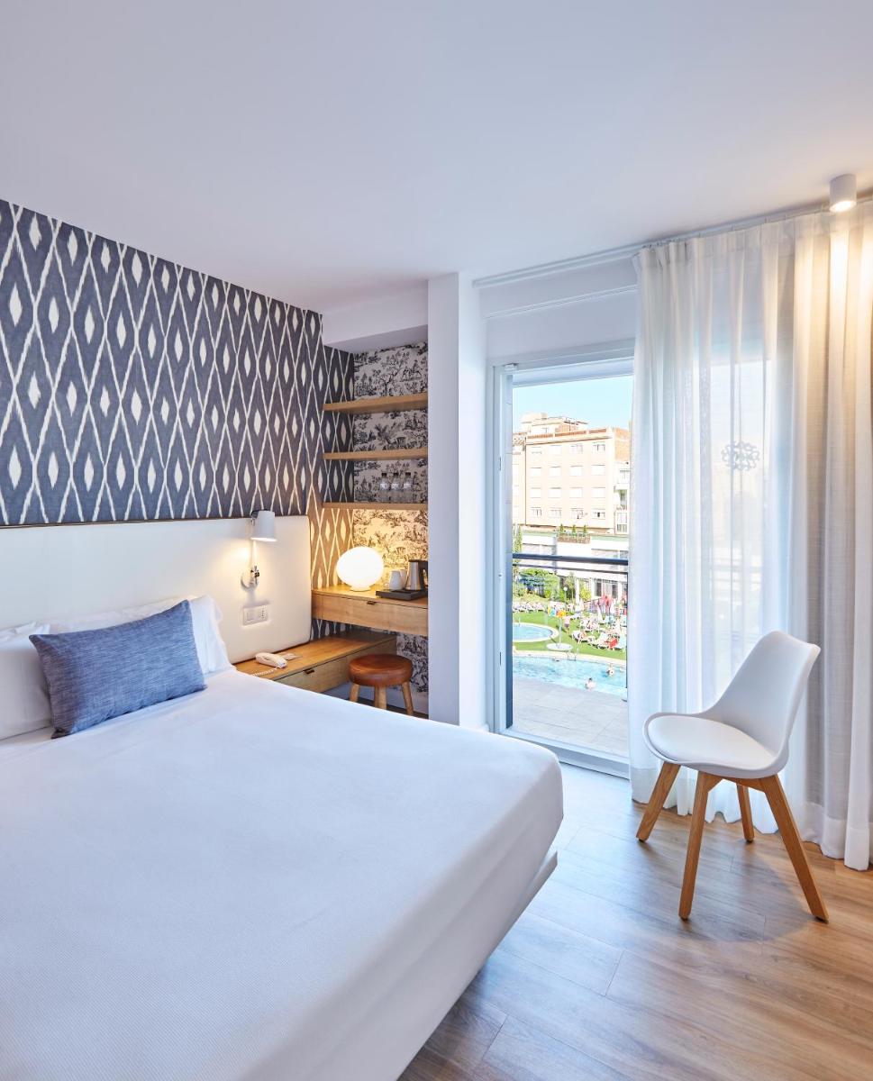 Un dormitorio con una cama y una silla y una ventana. en Hotel Anabel, en Lloret de Mar