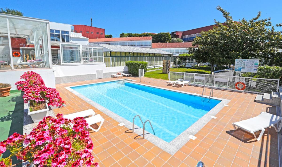 una piscina en un patio al lado de un edificio en Hotel Spa Congreso, en Teo