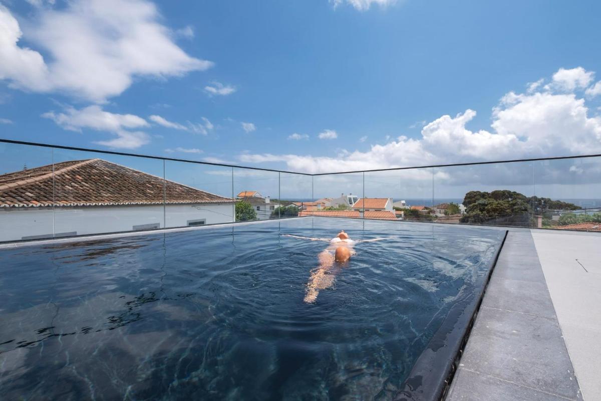 um cão na água numa piscina em Aqua - Pópulo Eco Village em Ponta Delgada