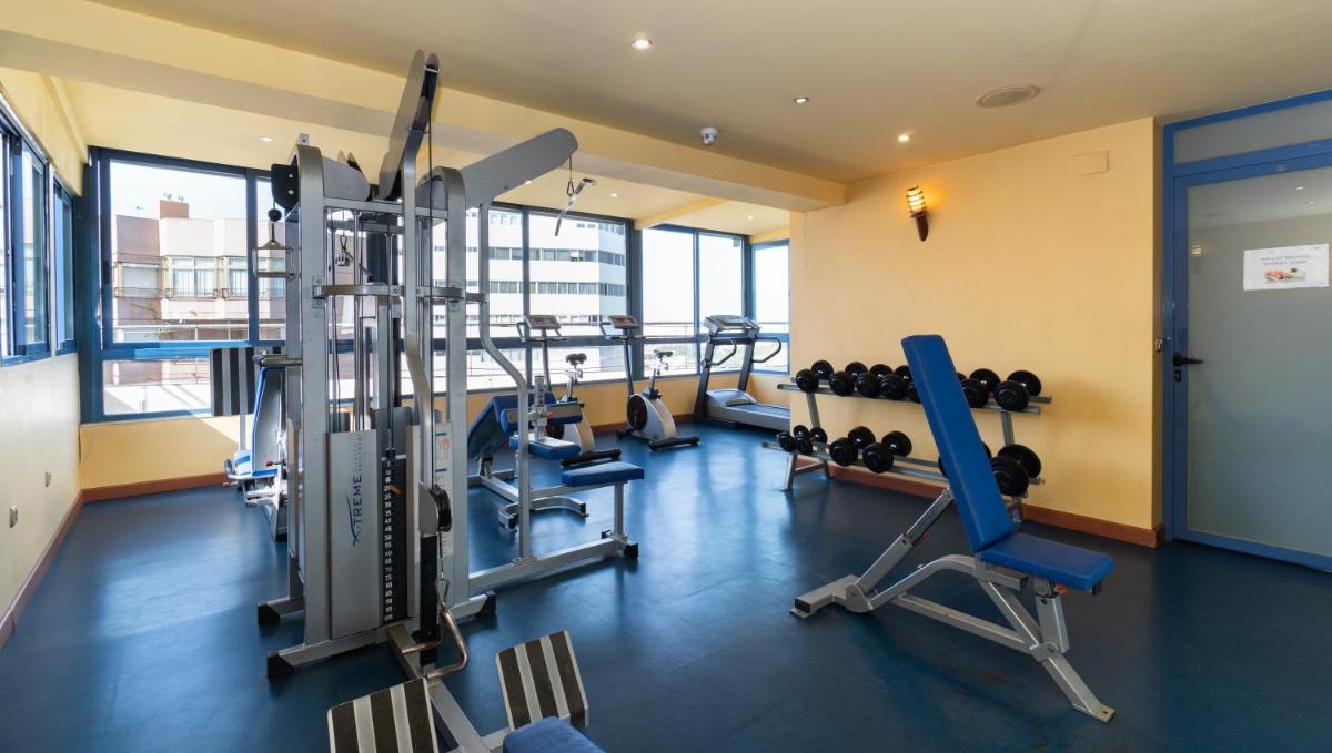 Un gimnasio con equipos cardiovasculares en un edificio. en Hotel MS Maestranza Málaga, en Málaga