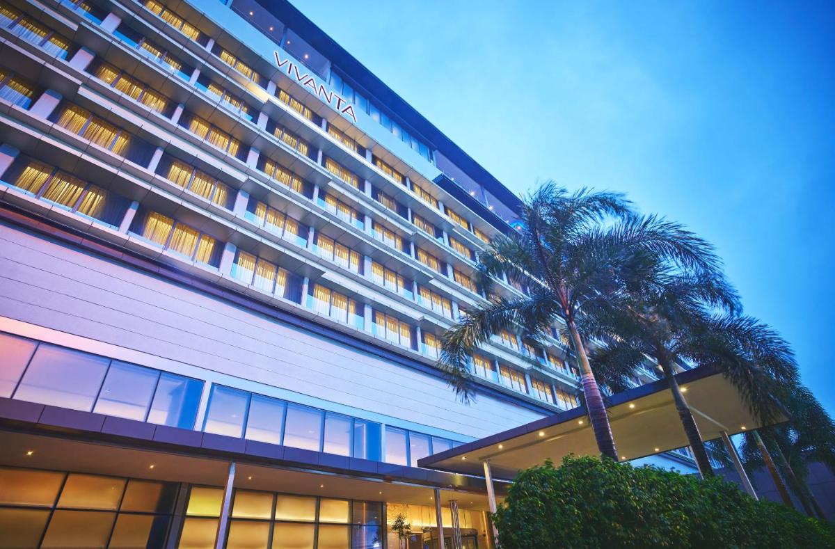 a tall building with a palm tree in front of it at Vivanta Kolkata EM Bypass in Kolkata