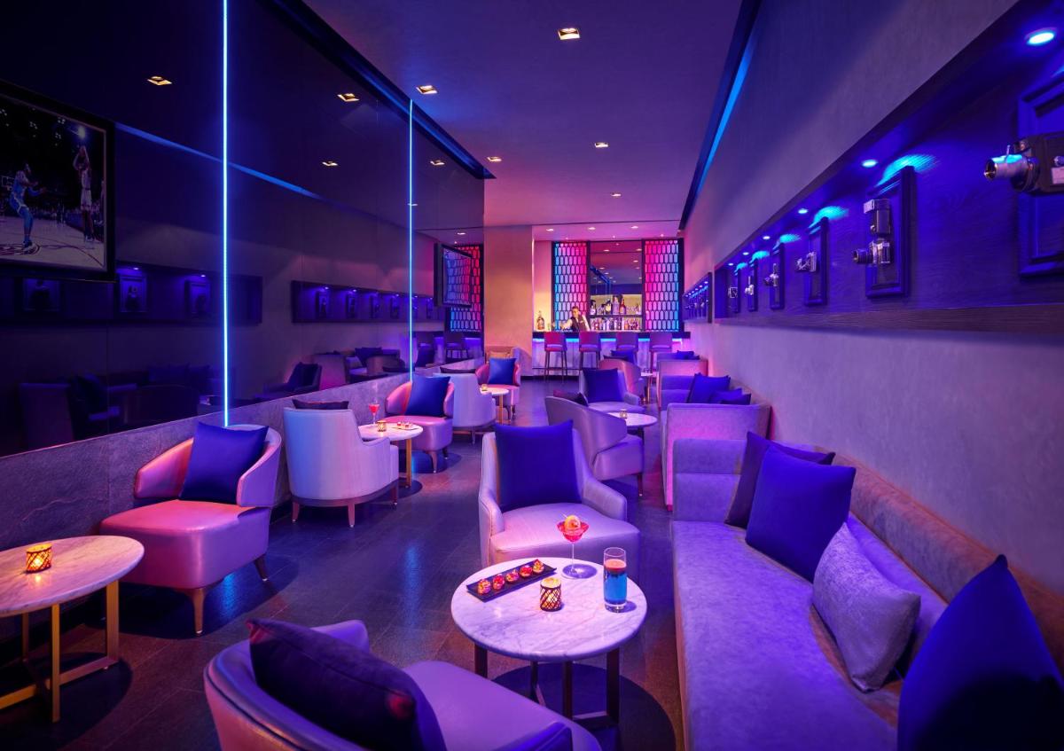 a restaurant with purple lighting and tables and chairs at Vivanta Kolkata EM Bypass in Kolkata